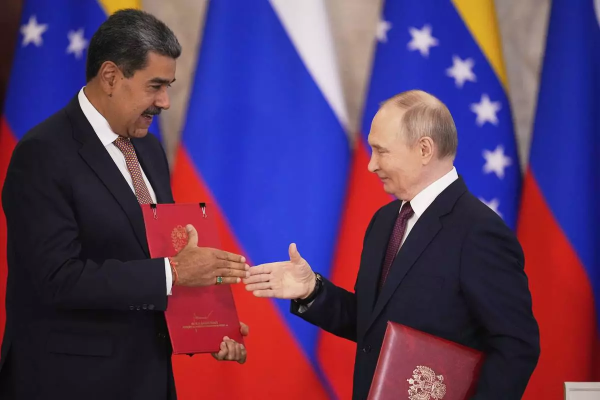 Russian President Vladimir Putin, right, and Venezuelan President Nicolas Maduro exchange documents during a signing ceremony following their talks at the Kremlin in Moscow, Russia, Wednesday, May 7, 2025, ahead of celebrations of the 80th anniversary of the Soviet Union's victory over Nazi Germany during the World War II. (AP Photo/Alexander Zemlianichenko)
