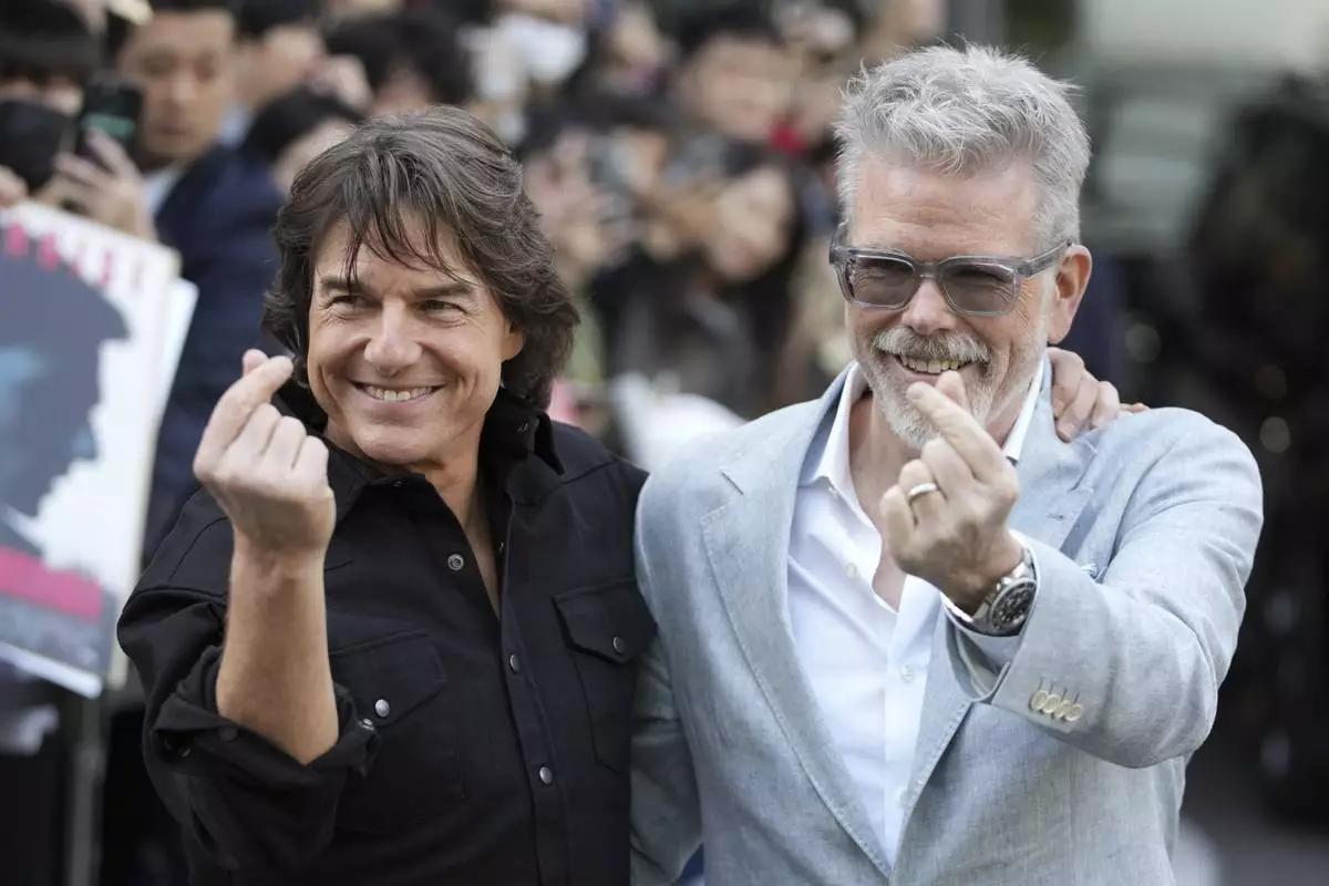 Actor Tom Cruise, left, and director Christopher McQuarrie pose for the photographers upon their arrival to promote their latest movie "Mission: Impossible - The Final Reckoning," at the Gimpo Airport in Seoul, South Korea, Wednesday, May 7, 2025. (AP Photo/Lee Jin-man)