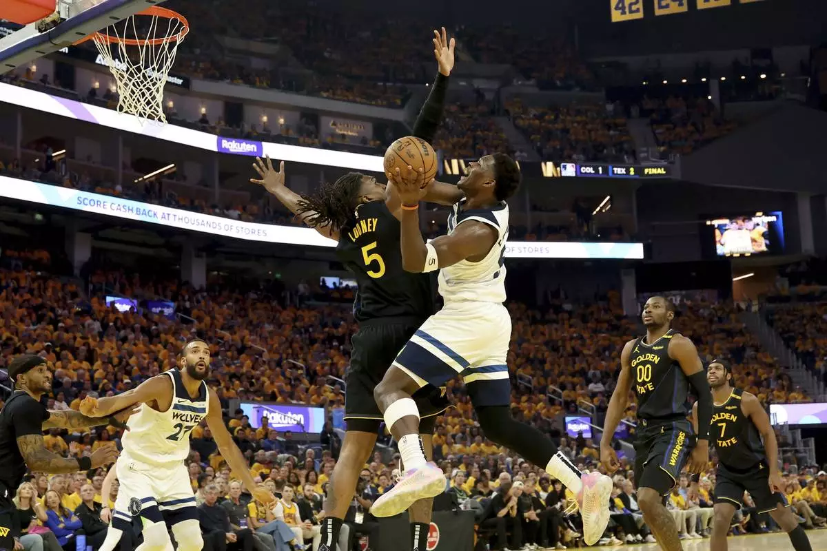 Minnesota Timberwolves guard Anthony Edwards, center right, looks to shoot against Golden State Warriors forward Kevon Looney, center left, during the first half of Game 4 in the Western Conference semifinals of the NBA basketball playoffs Monday, May 12, 2025, in San Francisco. (AP Photo/Jed Jacobsohn)