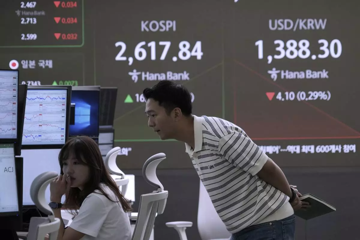 Currency traders watch monitors near a screen showing the Korea Composite Stock Price Index (KOSPI) and the foreign exchange rate between U.S. dollar and South Korean won, top right, at the foreign exchange dealing room of the KEB Hana Bank headquarters in Seoul, South Korea, Wednesday, May 21, 2025. (AP Photo/Ahn Young-joon)