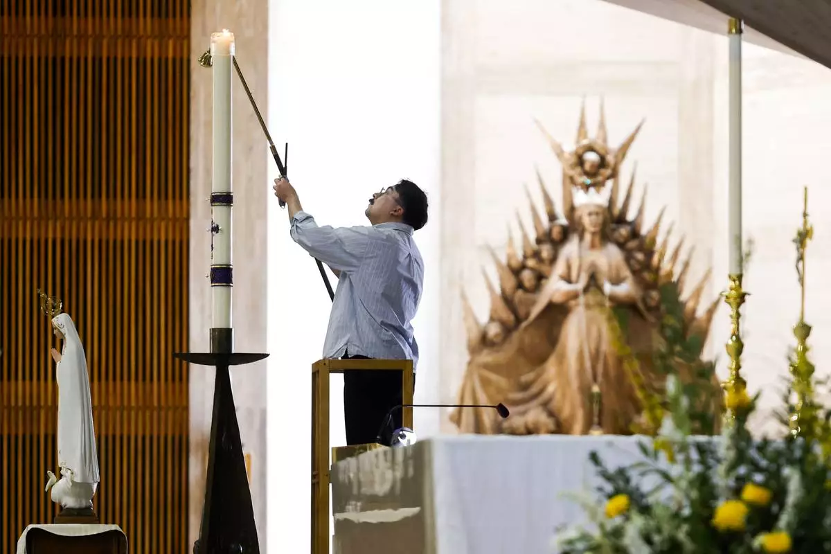 A man lights candles at an alter ahead of a daytime Mass at the Cathedral of Saint Mary of the Assumption in San Francisco, Thursday, May 8, 2025, after newly elected Pope Leo XIV was announced. (Jessica Christian/San Francisco Chronicle via AP)