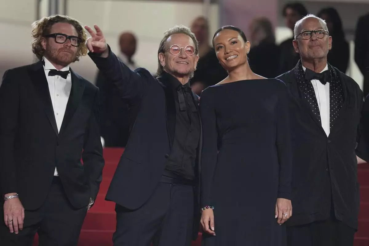Erik Messerschmid, from left, Bono, Kelly McNamara, and Jon Kamen pose for photographers upon arrival at the premiere of the film 'Bono: Stories of Surrender' at the 78th international film festival, Cannes, southern France, Friday, May 16, 2025. (AP Photo/Natacha Pisarenko)