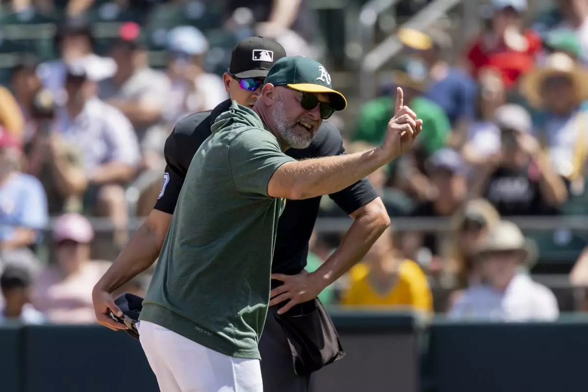 Athletics manager Mark Kotsay, front, argues with umpire Roberto Ortiz, back, after being ejected during the seventh inning of a baseball game against the Philadelphia Phillies, Sunday, May 25, 2025, in West Sacramento, Calif. (AP Photo/Sara Nevis)