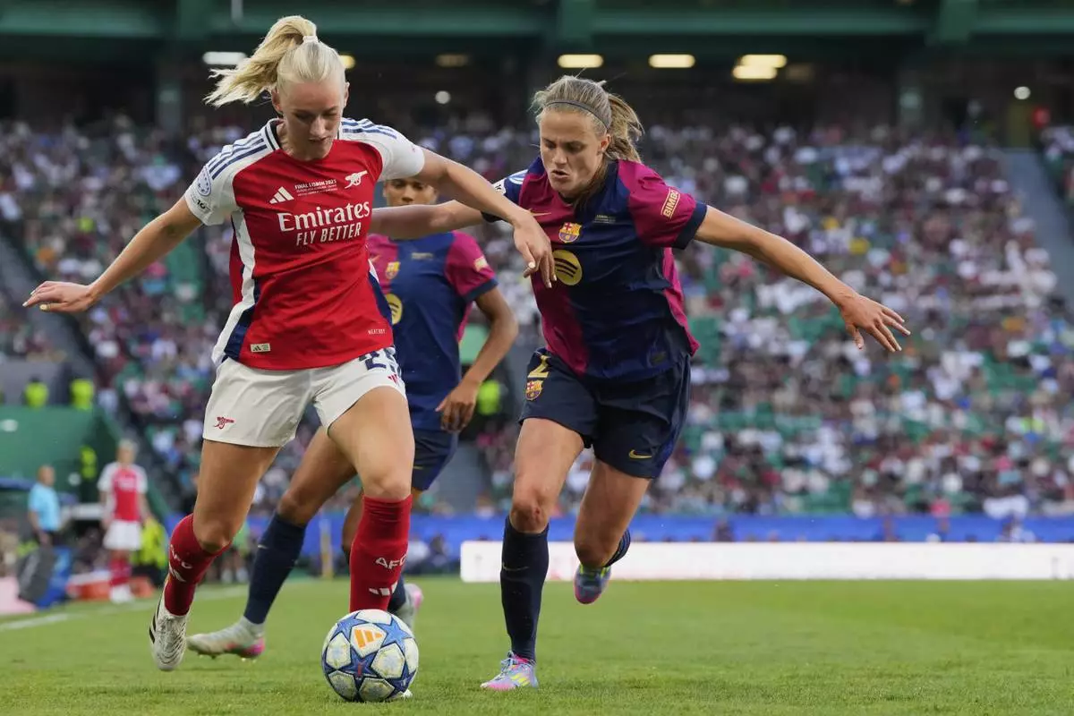 Arsenal's Stina Blackstenius, left, duels for the ball with Barcelona's Irene Paredes during the women's Champions League final soccer match between Arsenal and FC Barcelona at the Jose Alvalade Stadium in Lisbon, Saturday, May 24, 2025. (AP Photo/Jose Breton)