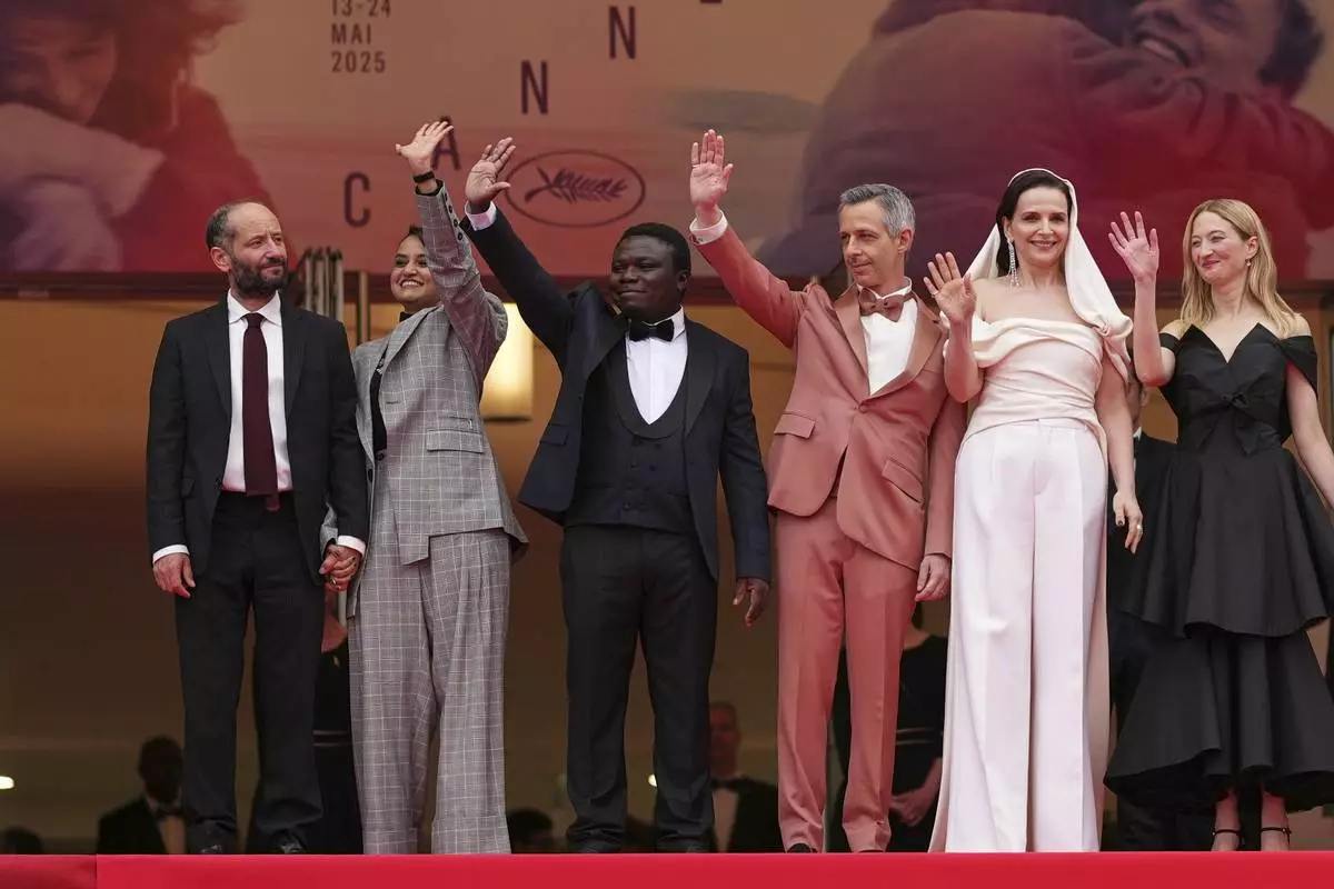 Jury president Juliette Binoche, second from right, and jury members Carlos Reygadas, from left, Payal Kapadia, Dieudo Hamadi, Jeremy Strong and Alba Rohrwacher pose for photographers during the opening ceremony red carpet of the 78th international film festival, Cannes, southern France, Tuesday, May 13, 2025. (Photo by Scott A Garfitt/Invision/AP)