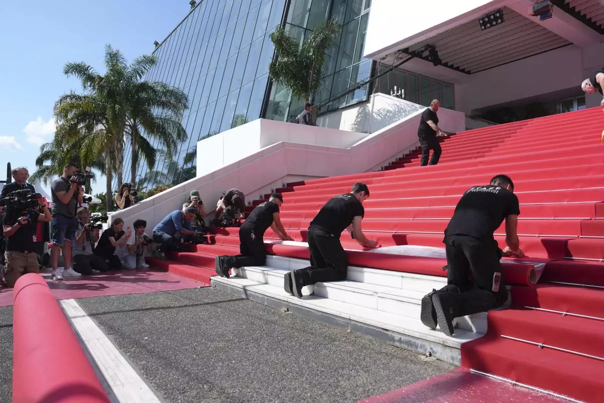 Crew members install the red carpet at the Palais des Festivals ahead of the opening ceremony of the 78th international film festival, Cannes, southern France, Tuesday, May 13, 2025. (Photo by Lewis Joly/Invision/AP)