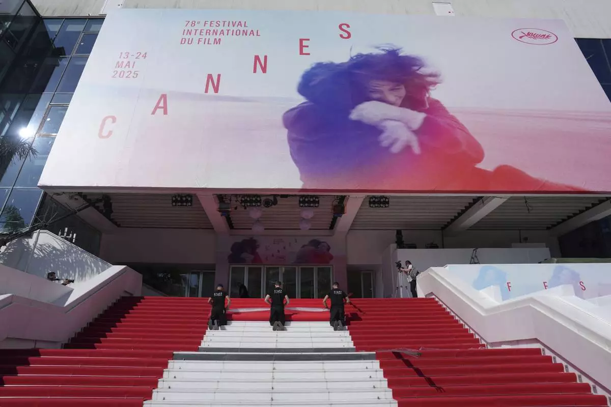 Crew members install the red carpet at the Palais des Festivals ahead of the opening ceremony of the 78th international film festival, Cannes, southern France, Tuesday, May 13, 2025. (Photo by Lewis Joly/Invision/AP)