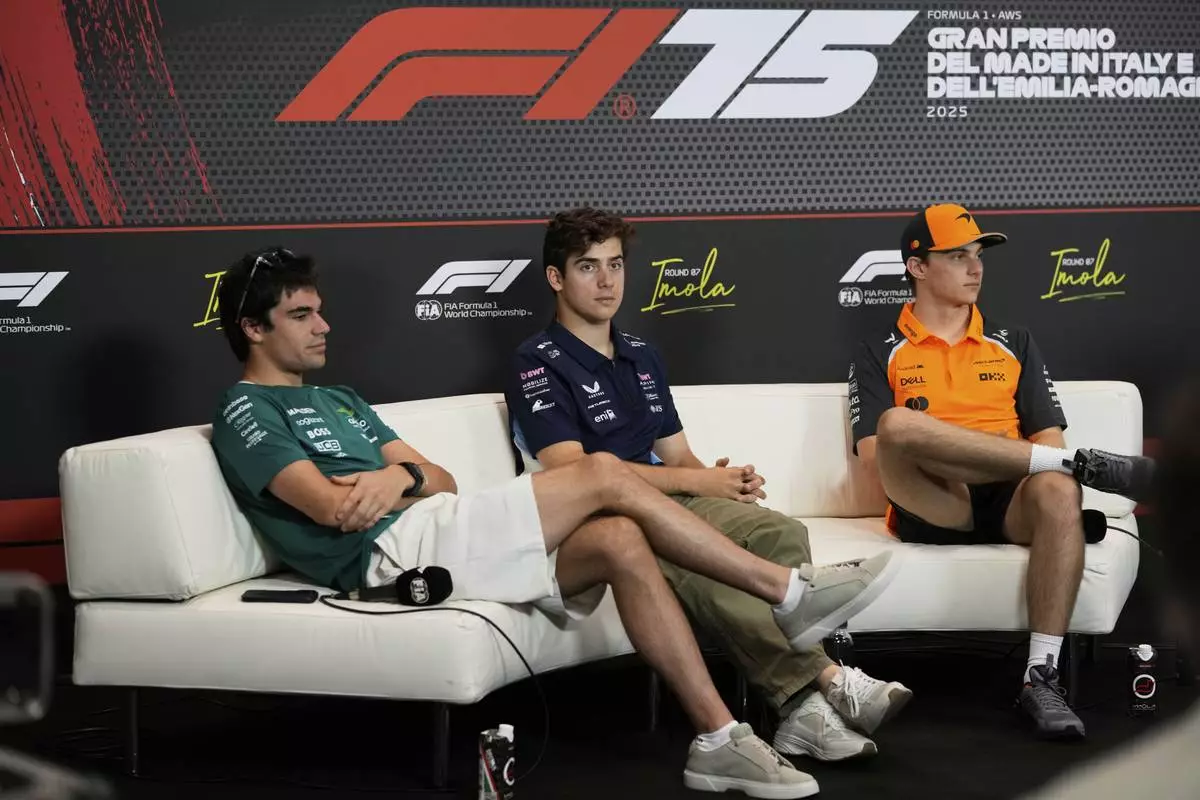 Alpine driver Franco Colapinto of Argentina, center, is flanked by Aston Martin driver Lance Stroll of Canada , left, and McLaren driver Oscar Piastri of Australia during a news conference at the Enzo and Dino Ferrari racetrack, ahead the Italy's Emilia Romagna Formula One Grand Prix in Imola, Italy, Thursday, May 15, 2025. (AP Photo/Luca Bruno)