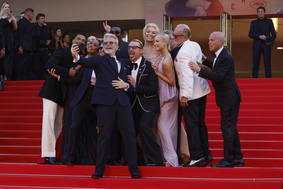 Greg Tarzan Davis, from left, Hayley Atwell, Angela Bassett, Tom Cruise, director Christopher McQuarrie, Tramell Tillman, Simon Pegg, Hannah Waddingham, Pom Klementieff, Esai Morales, and writer Erik Jendresen pose for a selfie upon arrival at the premiere of the film 'Mission: Impossible - The Final Reckoning' at the 78th international film festival, Cannes, southern France, Wednesday, May 14, 2025. (Photo by Joel C Ryan/Invision/AP)