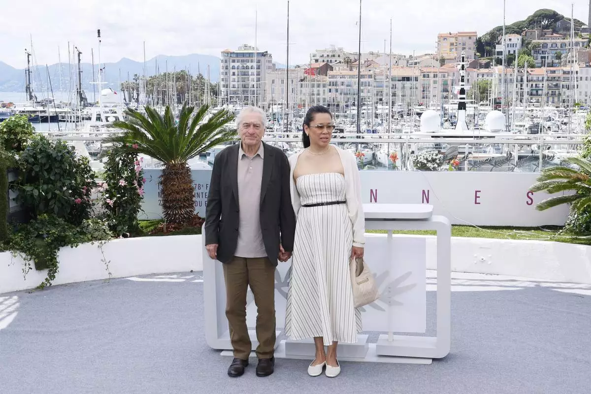 Honorary Palme d'Or recipient Robert De Niro, left, and Tiffany Chen pose for photographers during a photo call at the 78th international film festival, Cannes, southern France, Tuesday, May 13, 2025. (Photo by Joel C Ryan/Invision/AP)
