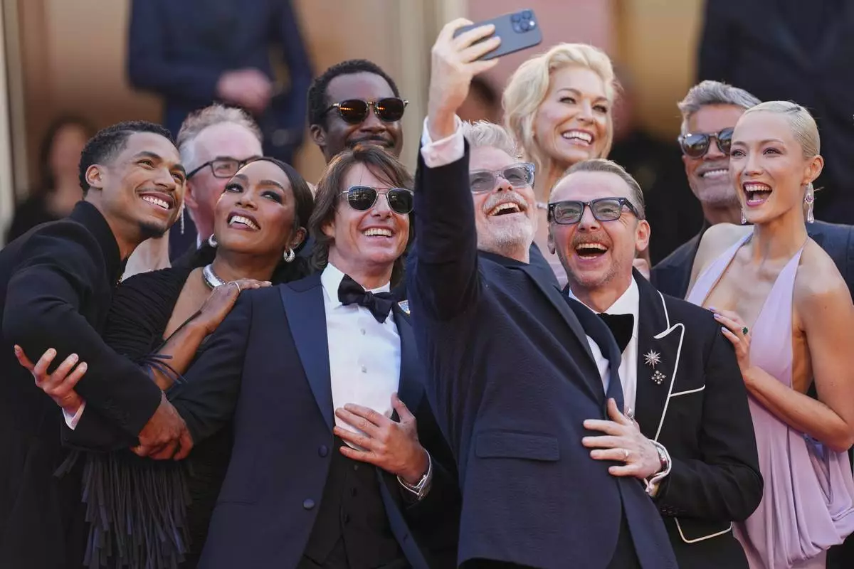Greg Tarzan Davis, from left, editor Eddie Hamilton, Angela Bassett, Tramell Tillman, Tom Cruise, director Christopher McQuarrie, Hannah Waddingham, Simon Pegg, Esai Morales, and Pom Klementieff take a selfie upon arrival at the premiere of the film 'Mission: Impossible - The Final Reckoning' at the 78th international film festival, Cannes, southern France, Wednesday, May 14, 2025. (Photo by Scott A Garfitt/Invision/AP)