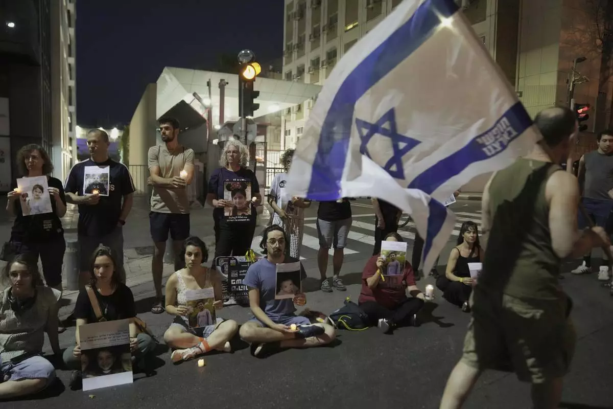 Protesters hold pictures of Palestinian children killed during Israel's military operation in the Gaza Strip in a protest demanding the end of the war, in Tel Aviv, Israel, Saturday, May 17, 2025. (AP Photo/Maya Alleruzzo)