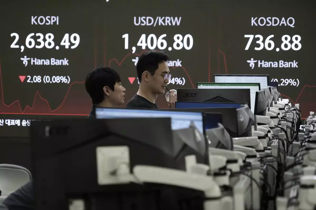 Currency traders watch monitors near a screen showing the Korea Composite Stock Price Index (KOSPI), top left, and the foreign exchange rate between U.S. dollar and South Korean won, top center, at the foreign exchange dealing room of the KEB Hana Bank headquarters in Seoul, South Korea, Thursday, May 15, 2025. (AP Photo/Ahn Young-joon)