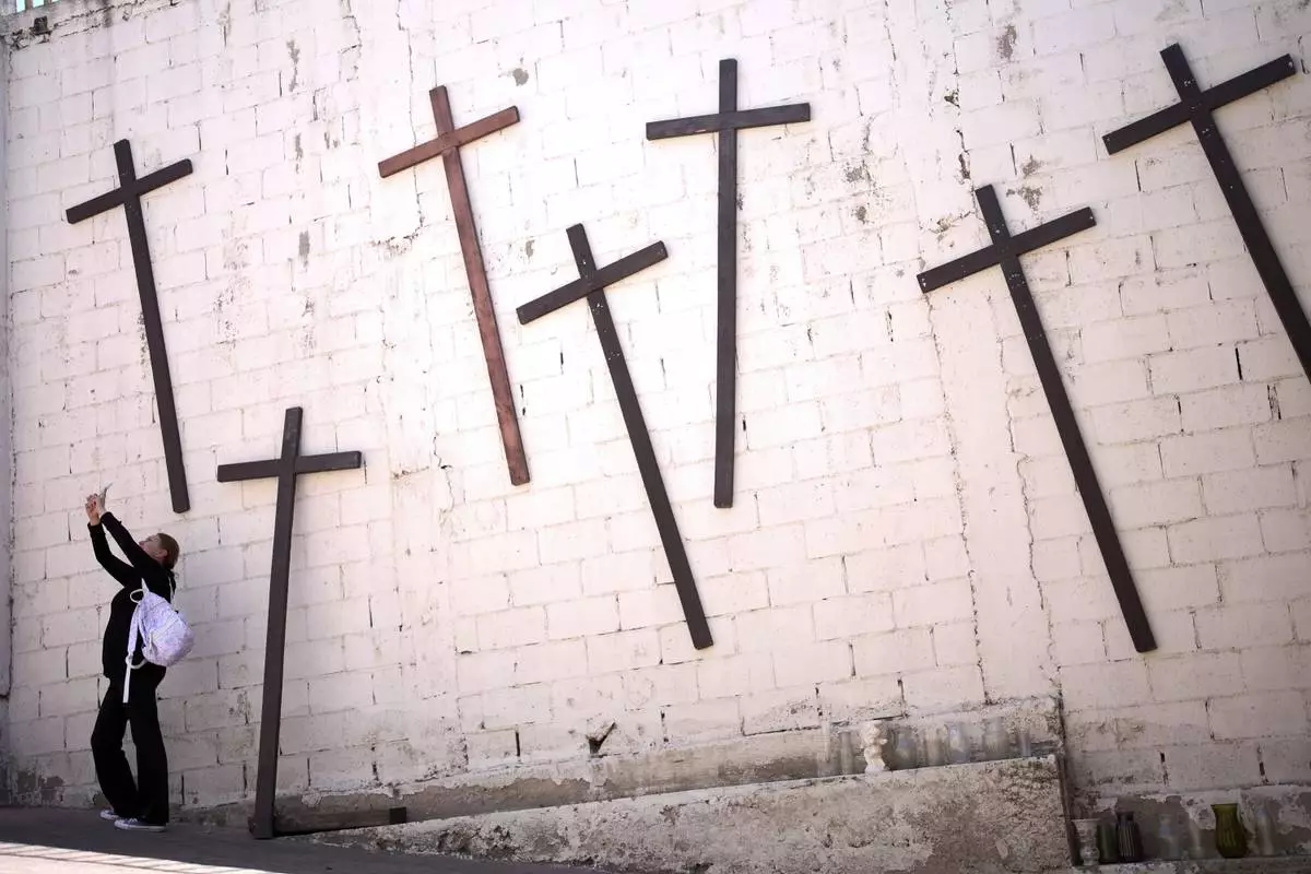A woman, who only gave her first name as Ana, takes a picture as she visits a parish named after the Peruvian saint, Santo Tomas de Porres, the day Cardinal Robert Prevost was announced as Pope Leo XIV, Thursday, May 8, 2025, in Tijuana, Mexico. (AP Photo/Gregory Bull)