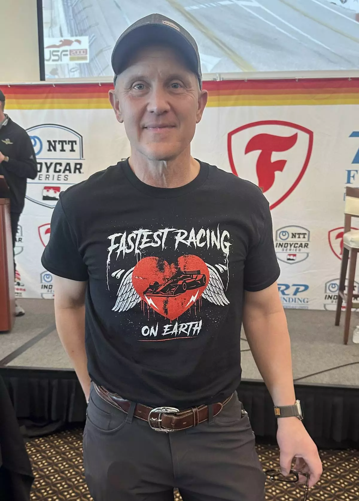 FOX Sports CEO &amp; Executive Producer Eric Shanks poses in a T-shirt he designed to promote the IndyCar auto racing season on March 4, 2025, in St. Petersburg, Fla. (AP Photo/Jenna Fryer)