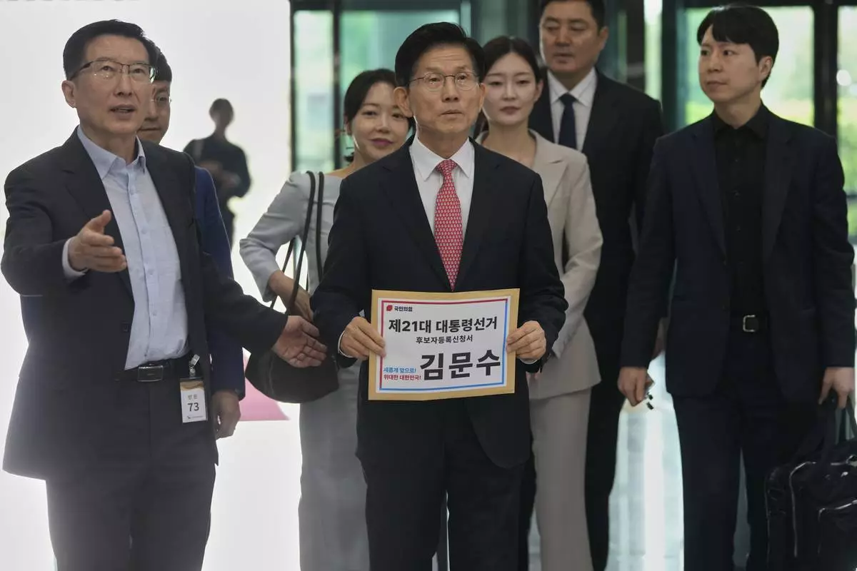 South Korea's People Power Party's presidential election candidate Kim Moon Soo, center, arrives to submit documents to register as a candidate to run in the June 3 presidential election, at the National Election Commission, Gwacheon, South Korea, Sunday, May 11, 2025. The letter read "The 21st Presidential election candidate registration application, Kim Moon Soo."(AP Photo/Ahn Young-joon)