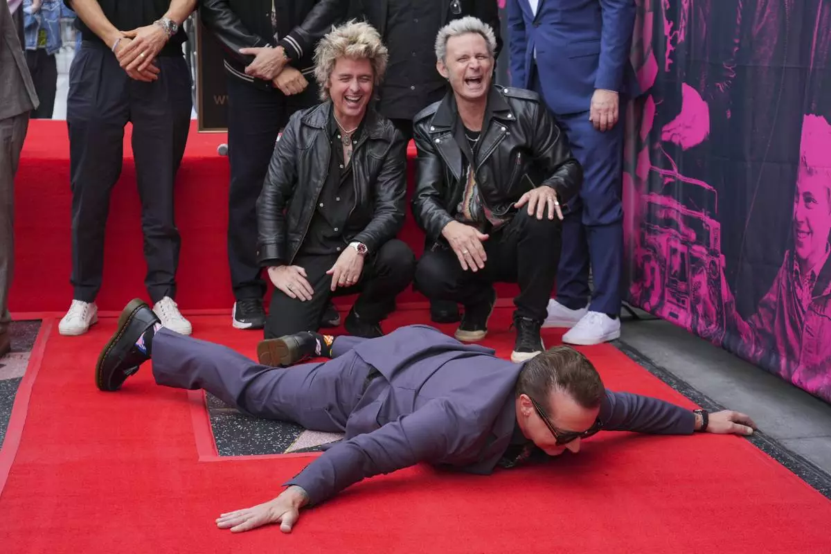 Tre Cool, from left, Billie Joe Armstrong, and Mike Dirnt of Green Day pose with their new star during a ceremony on the Hollywood Walk of Fame on Thursday, May 1, 2025, in Los Angeles. (AP Photo/Chris Pizzello)