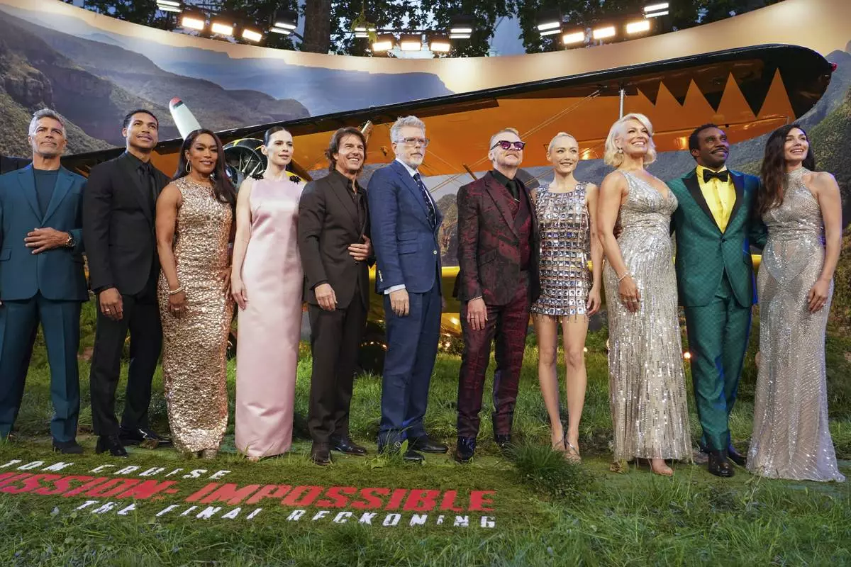 Esai Morales, from left, Greg Tarzan Davis, Angela Bassett, Hayley Atwell, Tom Cruise, director Christopher McQuarrie, Simon Pegg, Pom Klementieff, Hannah Waddingham, Tramell Tillman, and Mariela Garriga pose for photographers upon arrival at the premiere of the film 'Mission: Impossible - The Final Reckoning' on Thursday, May 15, 2025, in London. (Photo by Alberto Pezzali/Invision/AP)