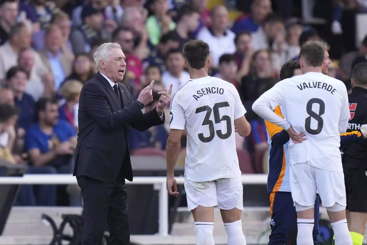 Real Madrid's head coach Carlo Ancelotti, left, gives instructions during the Spanish La Liga soccer match between Barcelona and Real Madrid at the Lluis Companys Olympic Stadium in Barcelona, Spain, Sunday, May 11, 2025. (AP Photo/Jose Breton)