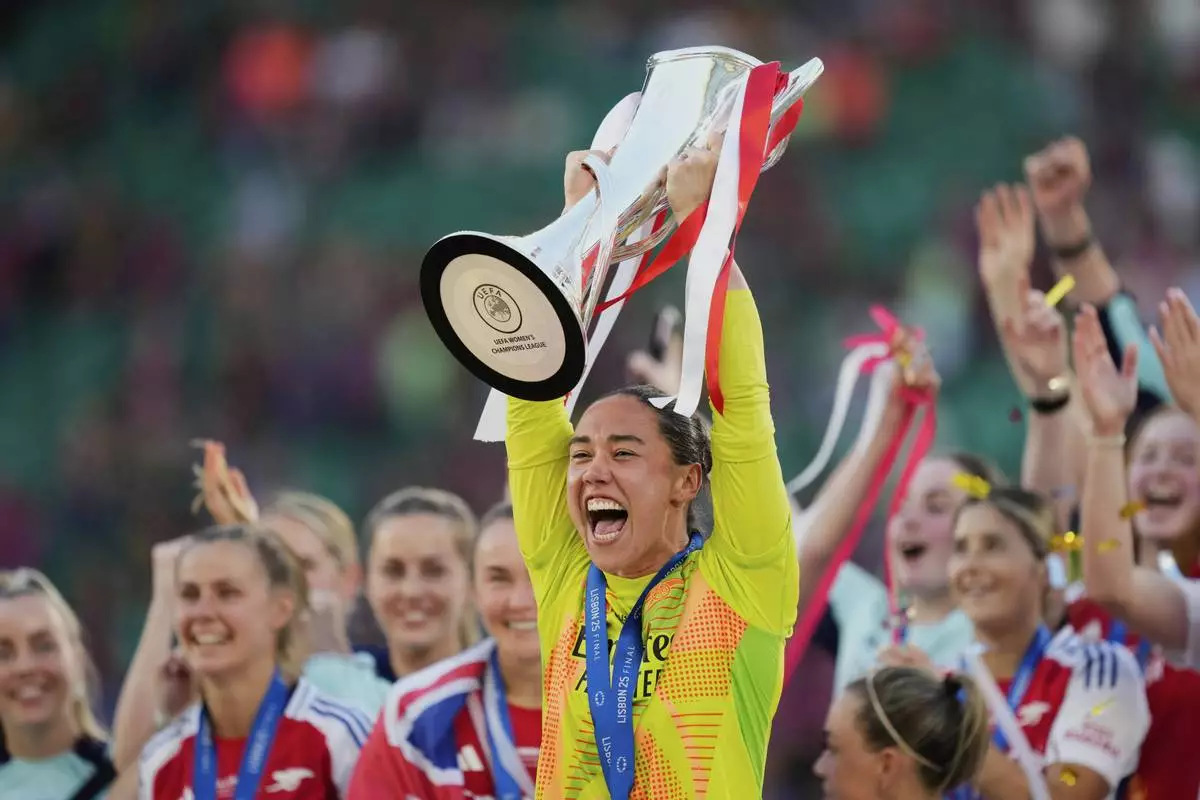Arsenal goalkeeper Manuela Zinsberger rises the winner's trophy after winning the women's Champions League final soccer match between Arsenal and FC Barcelona at the Jose Alvalade Stadium in Lisbon, Saturday, May 24, 2025. (AP Photo/Jose Breton)