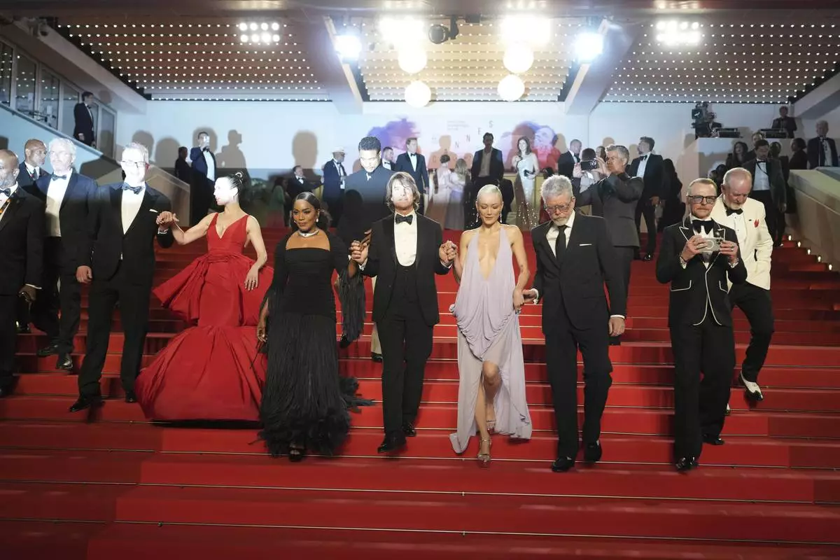 Editor Eddie Hamilton, from left, Hayley Atwell, Angela Bassett, Tom Cruise, Pom Klementieff, director Christopher McQuarrie, Simon Pegg and writer Erik Jendresen pose for photographers upon departure from the premiere of the film 'Mission: Impossible – The Final Reckoning' at the 78th international film festival, Cannes, southern France, Wednesday, May 14, 2025. (AP Photo/Natacha Pisarenko)