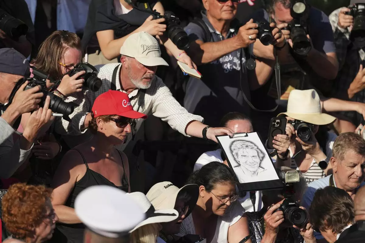 Tom Cruise, bottom right, signs autographs upon arrival for the premiere of the film 'Mission: Impossible - The Final Reckoning' at the 78th international film festival, Cannes, southern France, Wednesday, May 14, 2025. (Photo by Lewis Joly/Invision/AP)