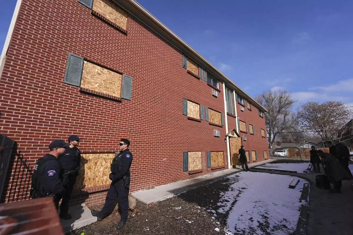 FILE - Officers gather outside one of the condemned buildings of an apartment complex called The Edge at Lowry after a news conference to outline that the five housing structures have been closed by the city, Feb. 19, 2025, in Aurora, Colo. (AP Photo/David Zalubowski, File)