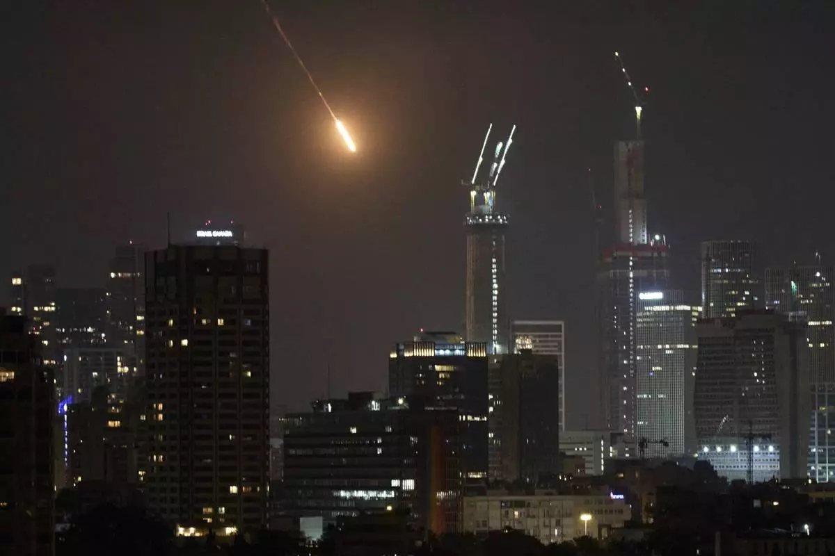 The trace of a projectile is seen before hitting Tel Aviv, Israel, early Saturday, June 14, 2025. (AP Photo/Leo Correa)