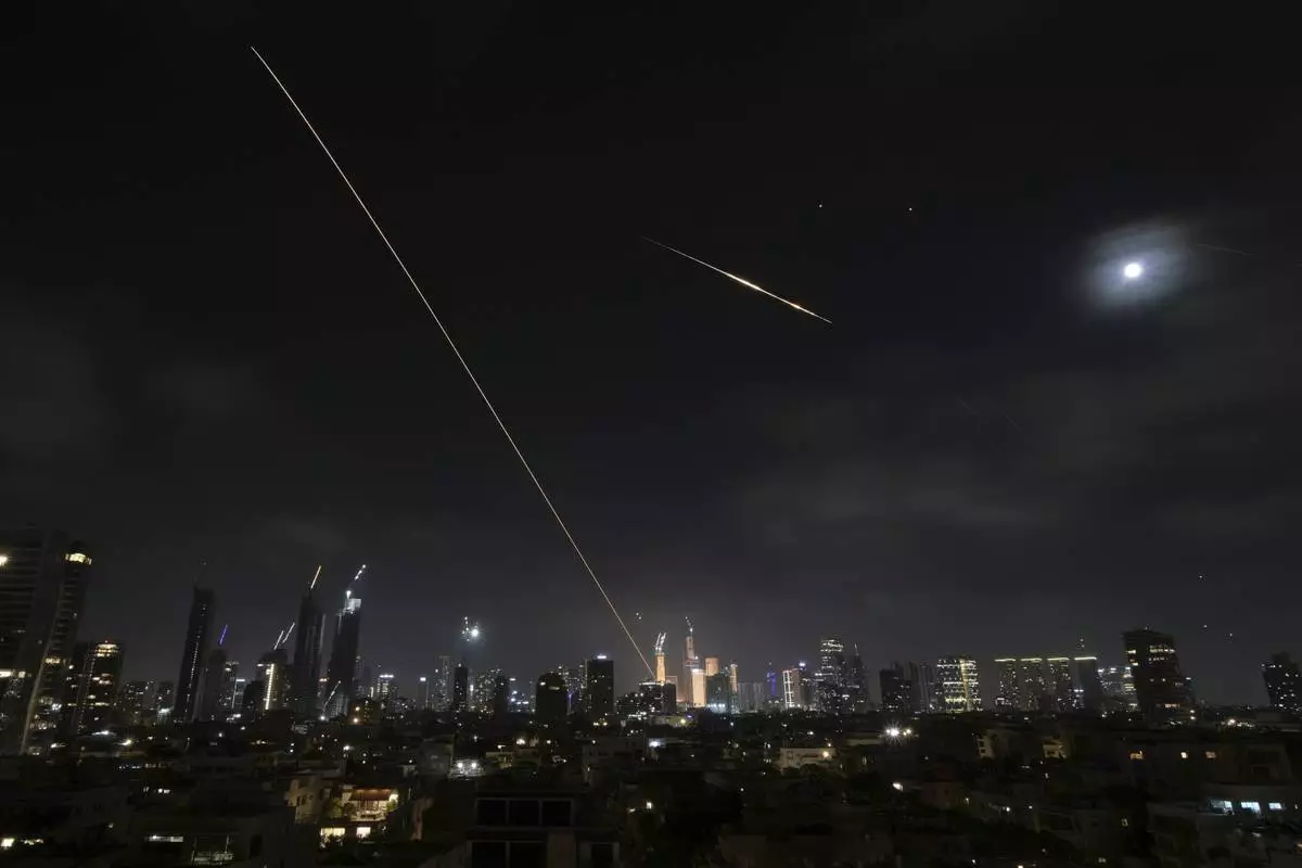 The trace of a projectile is seen as it hits buildings in Tel Aviv, Israel, early Saturday, June 14, 2025. (AP Photo/Leo Correa)