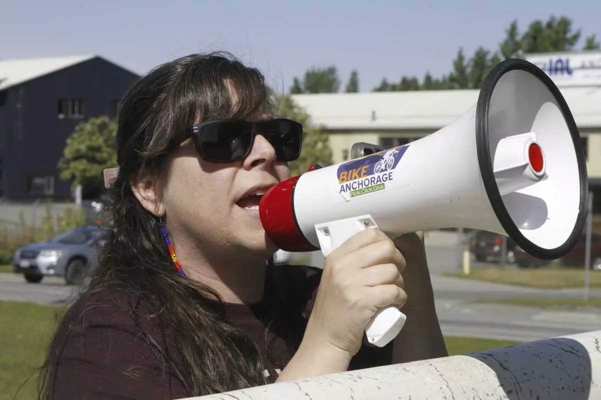 Demonstrator Courtney Moore uses a bullhorn Thursday, June 12, 2025, in Anchorage, Alaska, to protest the detainment of about 40 people being held there under the custody of the Immigration and Customs Enforcement federal agency. (AP Photo/Mark Thiessen)
