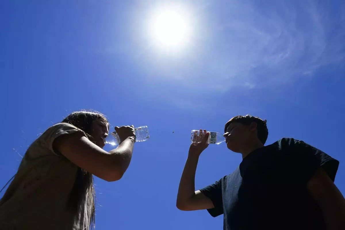 FILE - Tony Berastegui Jr., right, and his sister Giselle Berastegui drink water, July 17, 2023, in Phoenix. (AP Photo/Ross D. Franklin, File)