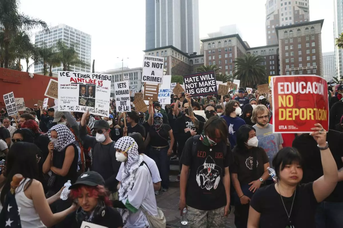Attendees listen to a speaker during a protest at Pershing Square, Wednesday, June 11, 2025, in Los Angeles. (AP Photo/Ethan Swope)