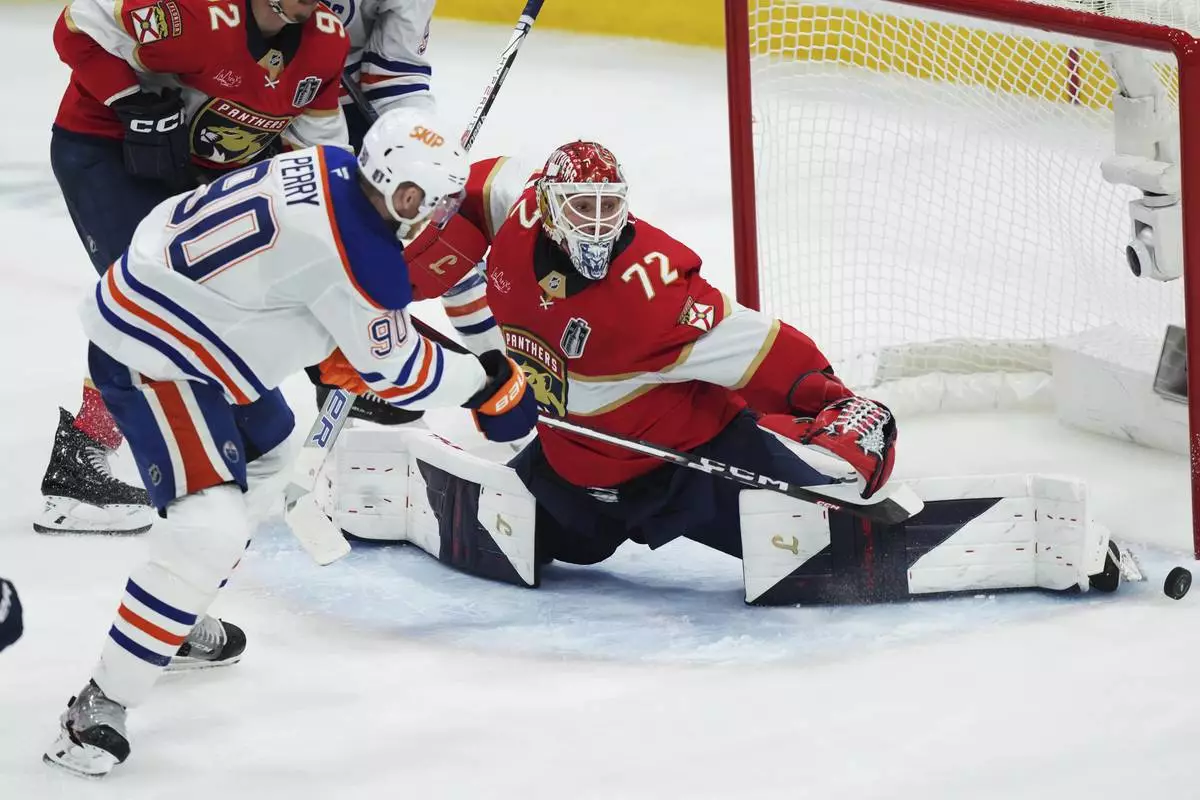 Edmonton Oilers' Corey Perry (90) is stopped by Florida Panthers goalie Sergei Bobrovsky (72) during the third period in Game 4 of the NHL hockey Stanley Cup Final in Sunrise, Fla., Thursday, June 12, 2025. (Nathan Denette/The Canadian Press via AP)