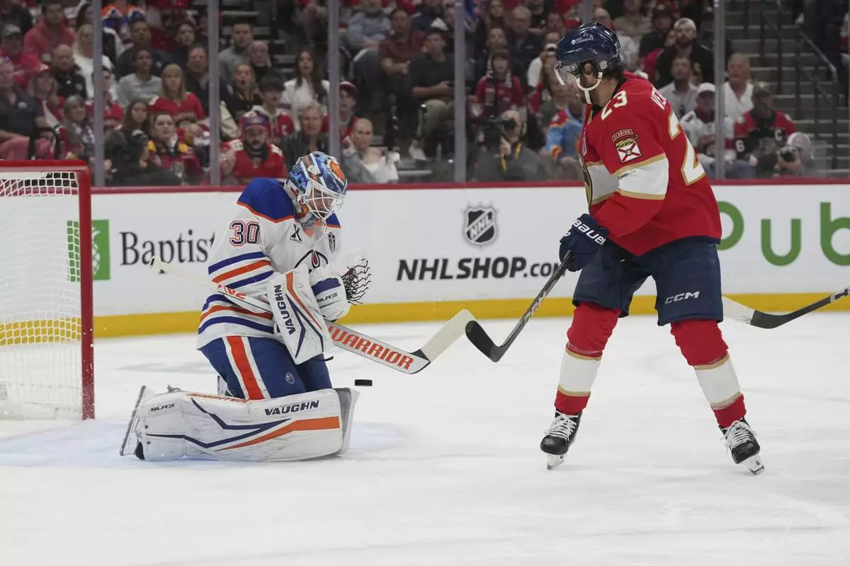 Florida Panthers center Carter Verhaeghe (23) watches as Edmonton Oilers goaltender Calvin Pickard (30) stops a shot on goal during the third period of Game 4 of the NHL hockey Stanley Cup Final Thursday, June 12, 2025, in Sunrise, Fla. (AP Photo/Lynne Sladky)