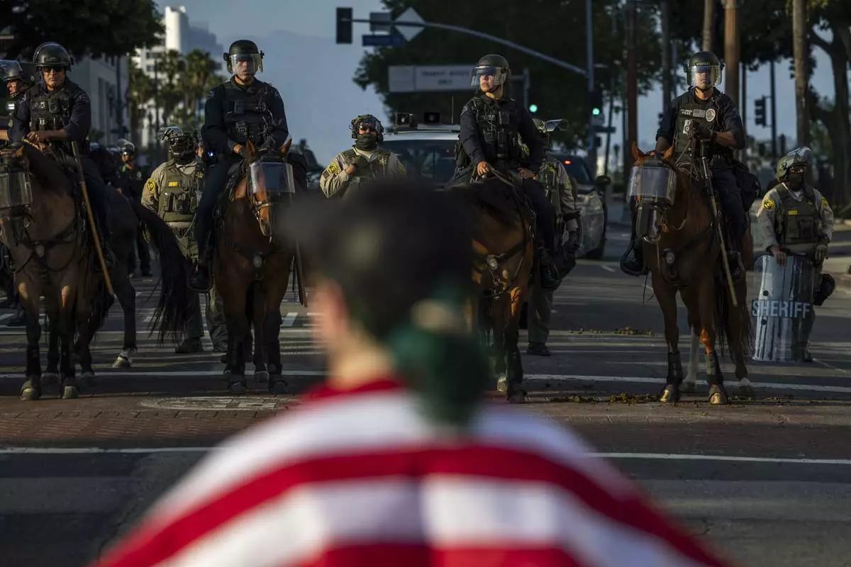 Police confront a protesters outside City Hall during protests over federal immigration enforcement raids on Wednesday, June 11, 2025, in Los Angeles. (AP Photo/Ethan Swope)