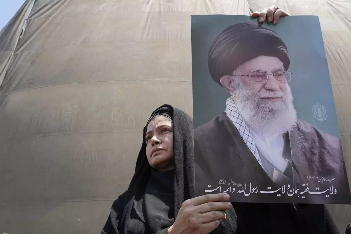 An Iranian protester holds up a poster of the Supreme Leader Ayatollah Ali Khamenei in an anti-Israeli gathering in Tehran, Iran, Friday, June 13, 2025. (AP Photo/Vahid Salemi)
