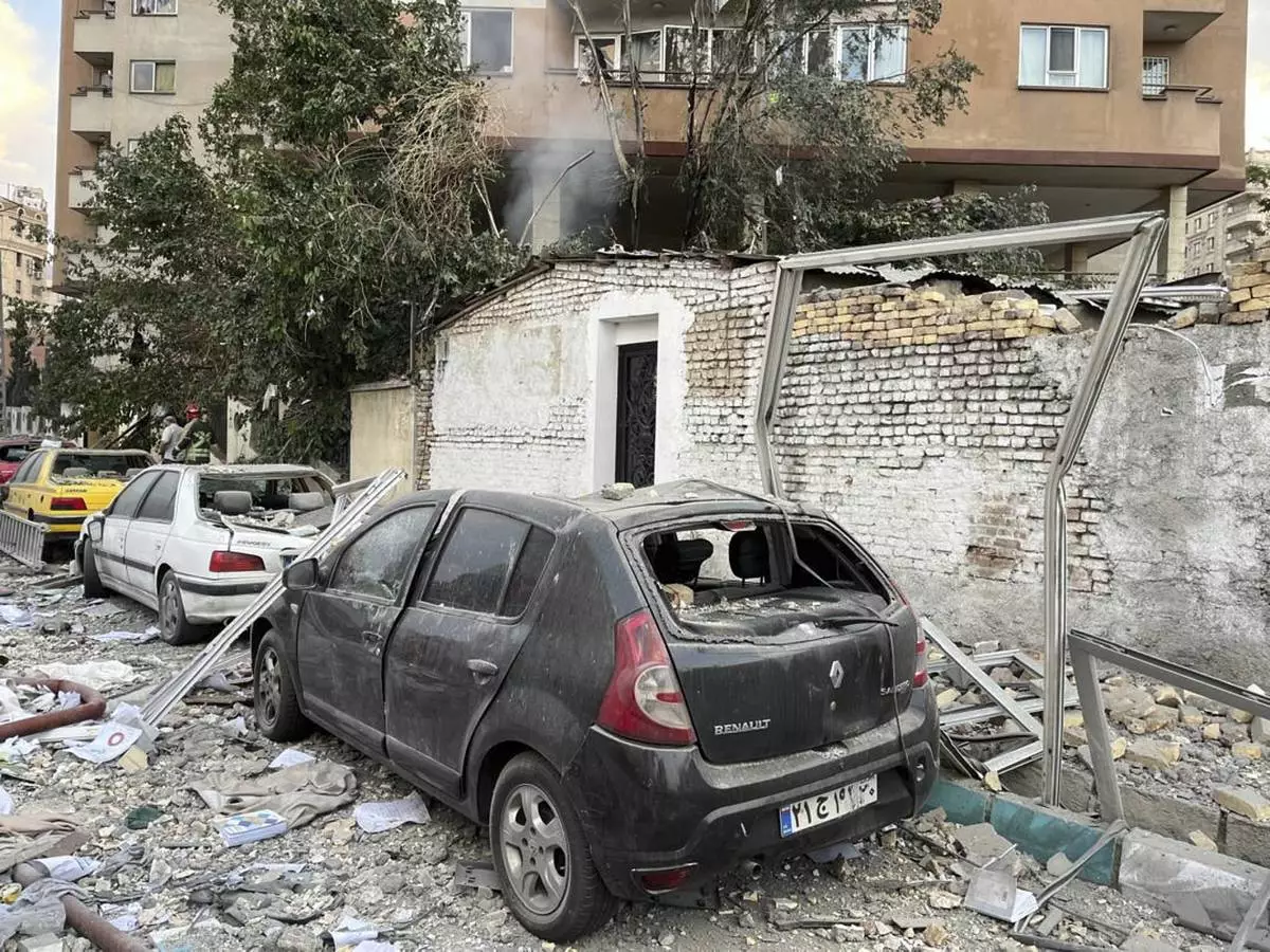 Debris from an apartment building is seen on top of parked cars after a strike in Tehran, Iran, early Friday, June 13, 2025. Israel attacked Iran's capital early Friday, with explosions booming across Tehran.(AP Photo/Vahid Salemi)