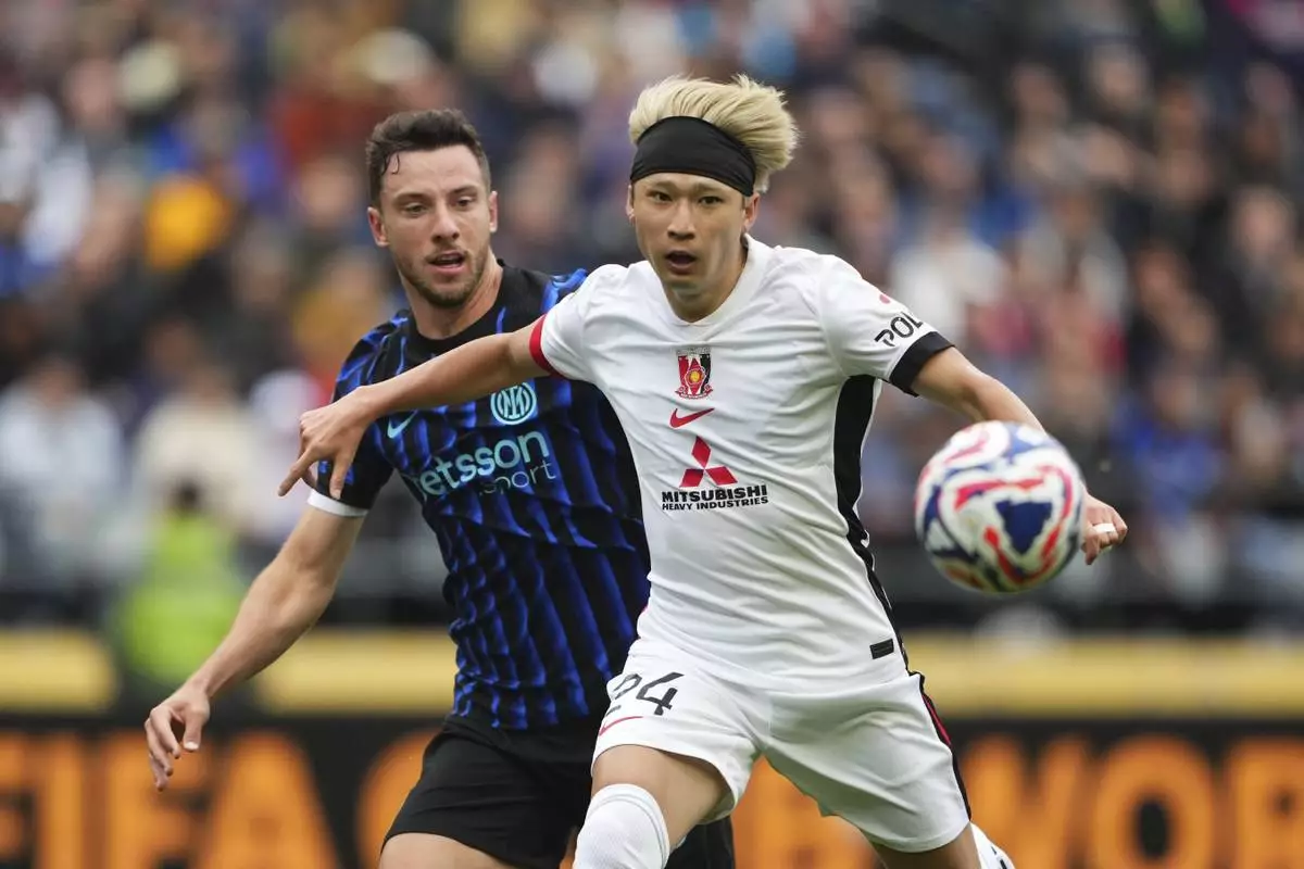 Inter Milan's Carlos Augusto and Urawa Red Diamonds' Yusuke Matsuo battle during the Club World Cup Group E soccer match between Inter Milan and Urawa Red Diamonds in Seattle, Saturday, June 21, 2025. (AP Photo/Lindsey Wasson)