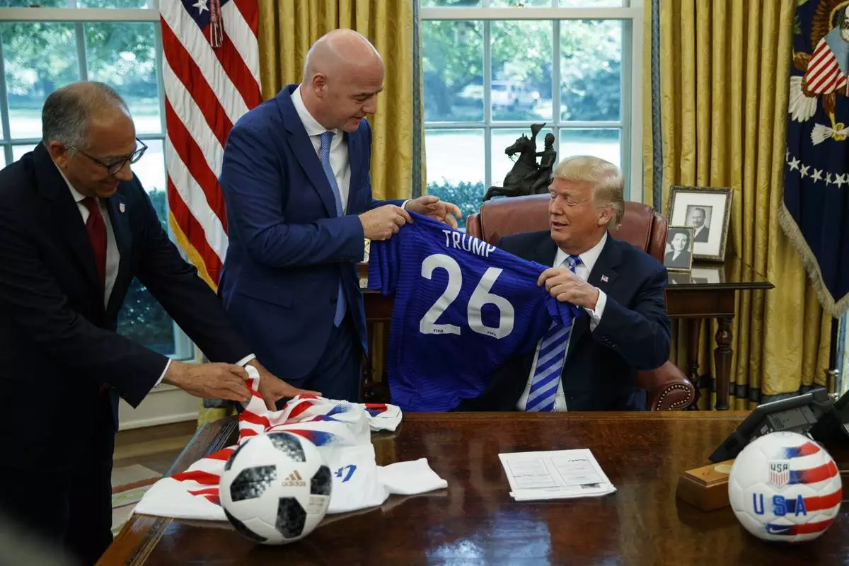 FILE - United States Soccer Federation president Carlos Cordeiro, left, and FIFA president Gianni Infantino present President Donald Trump with soccer jerseys during a meeting in the Oval Office of the White House, Tuesday, Aug. 28, 2018, in Washington. (AP Photo/Evan Vucci, File)