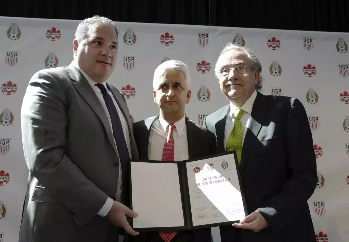 FILE - Victor Montagliani, left, President of the Canadian Soccer Association, Sunil Gulati, center, President of the United States Soccer Federation, and Decio de Maria, President of the Mexican Football Federation, show their unified bid to co-host the 2026 FIFA World Cup soccer tournament, Monday, April 10, 2017, in New York. (AP Photo/Mark Lennihan, File)