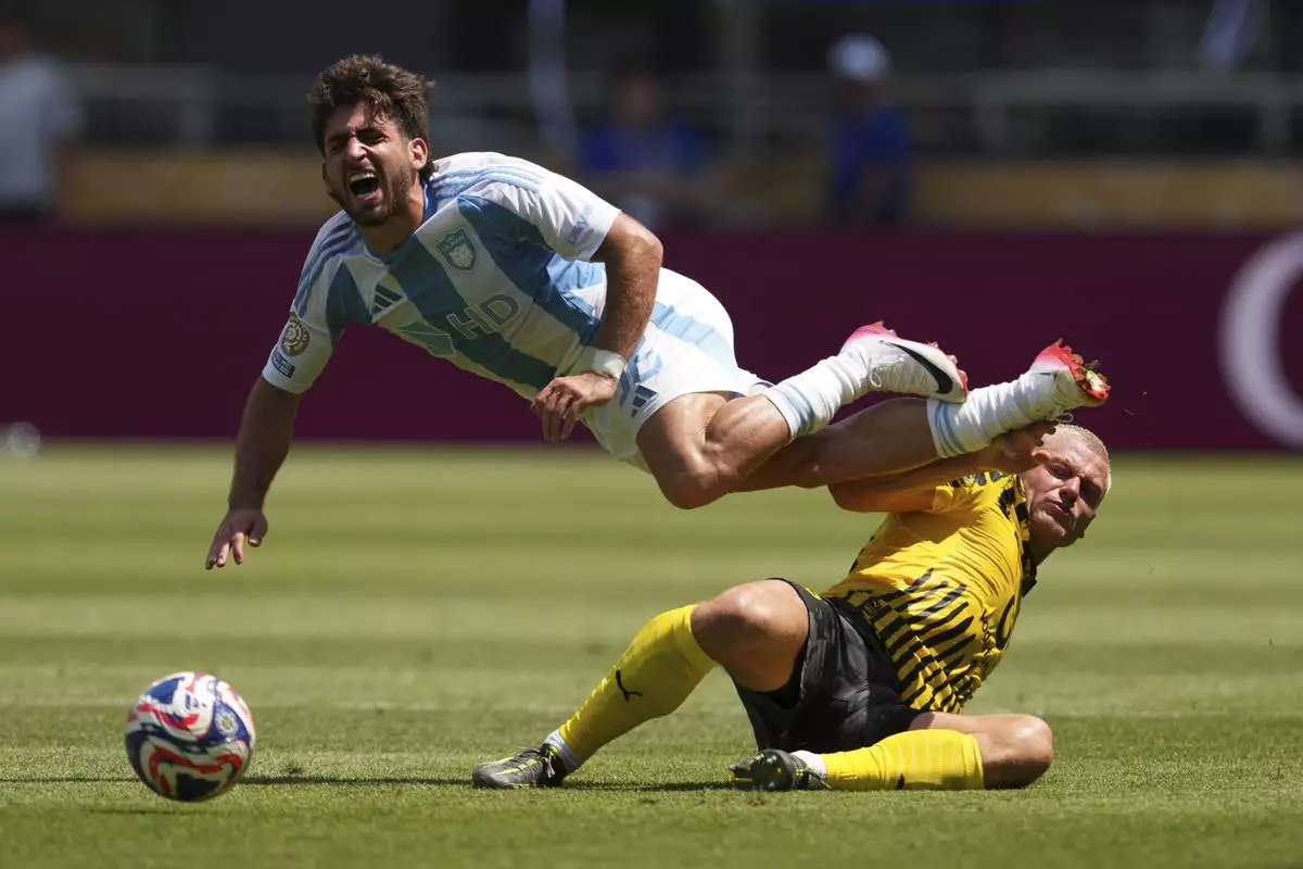 Borussia Dortmund's Julian Ryerson, bottom, stops Ulsan HD's Matias Lacava during the Club World Cup Group F soccer match between Borussia Dortmund and Ulsan in Cincinnati, Wednesday, June 25, 2025. (AP Photo/Jeff Dean)