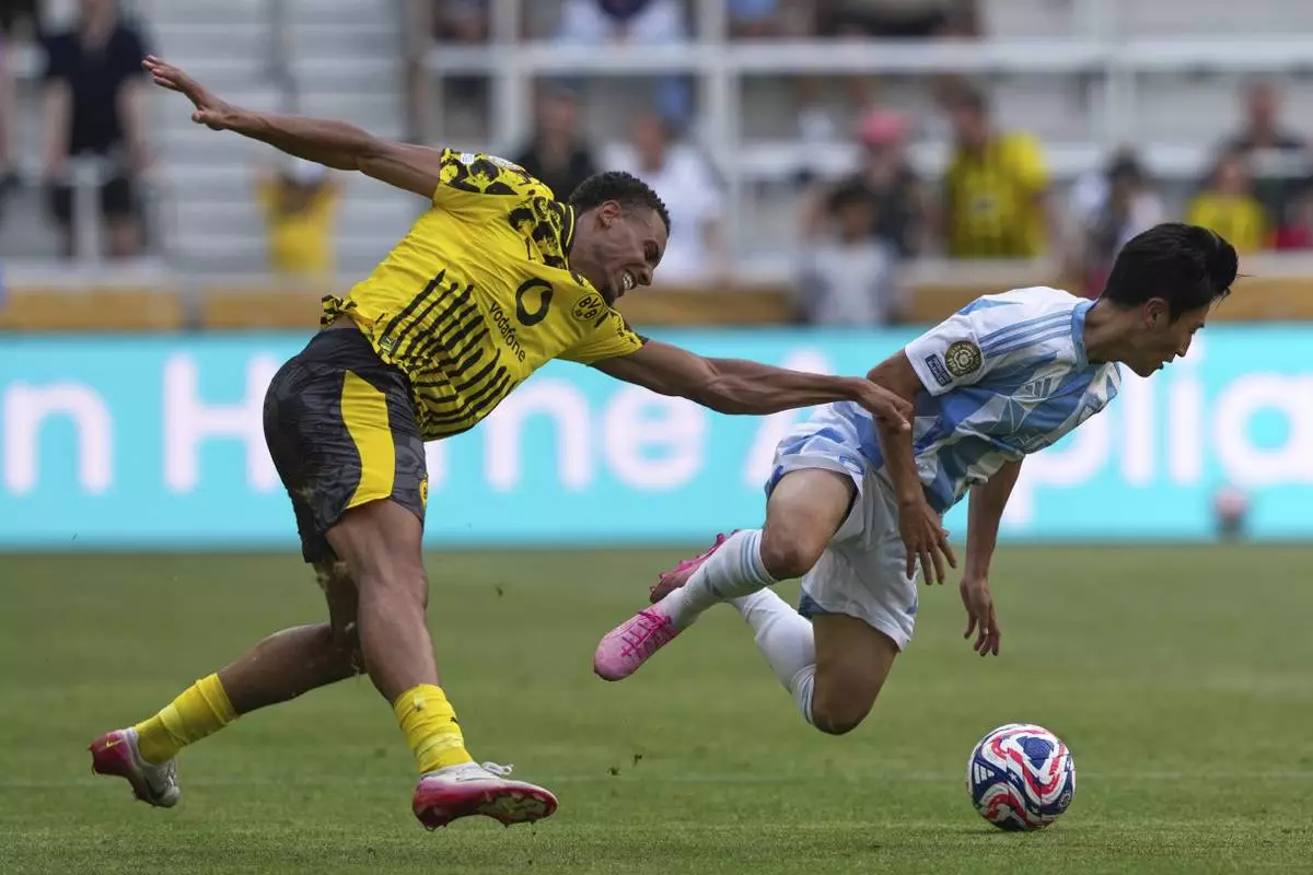 Borussia Dortmund's Felix Nmecha stops Ulsan HD's Lee Jin-hyun during the Club World Cup Group F soccer match between Borussia Dortmund and Ulsan in Cincinnati, Wednesday, June 25, 2025. (AP Photo/Carolyn Kaster)