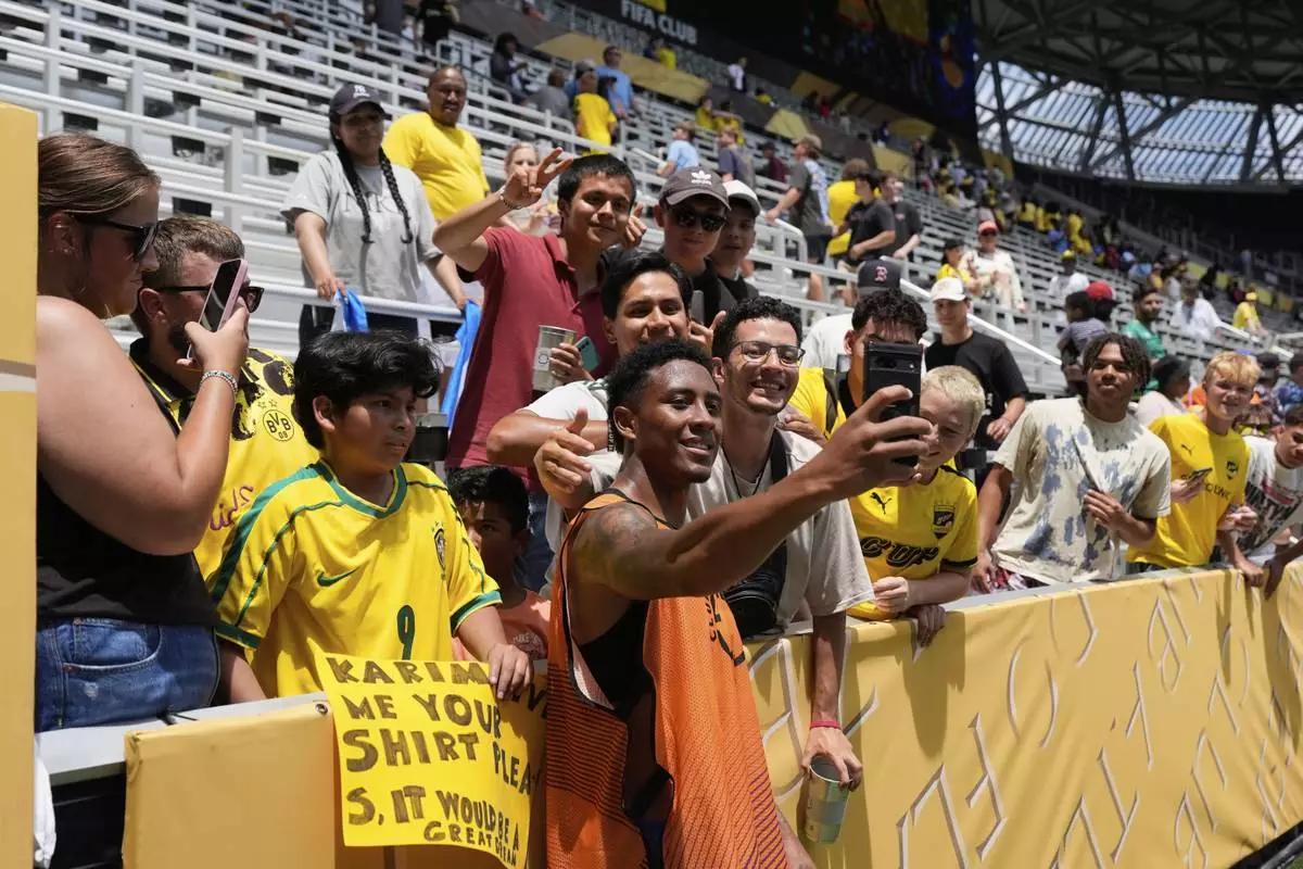 Mamelodi Sundowns' Lucas Ribeiro Costa (10) poses for a selfie with fans after the Club World Cup Group F soccer match between Mamelodi Sundowns and Borussia Dortmund in Cincinnati, Saturday, June 21, 2025. (AP Photo/Carolyn Kaster)