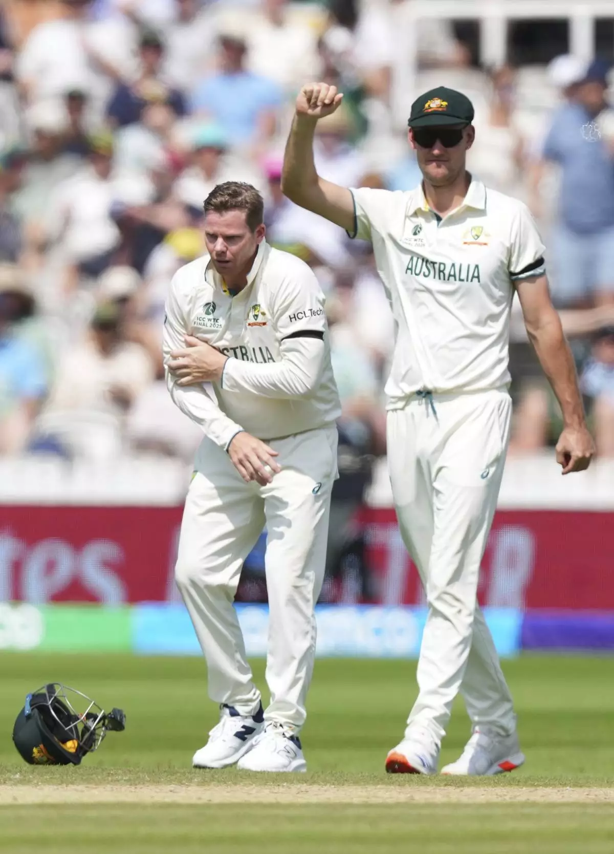Australia's Steve Smith, left, reacts in pain after getting hurt while fielding on day three of the World Test Championship final between South Africa and Australia at Lord's cricket ground in London, Friday, June 13, 2025. (AP Photo/Kirsty Wigglesworth)