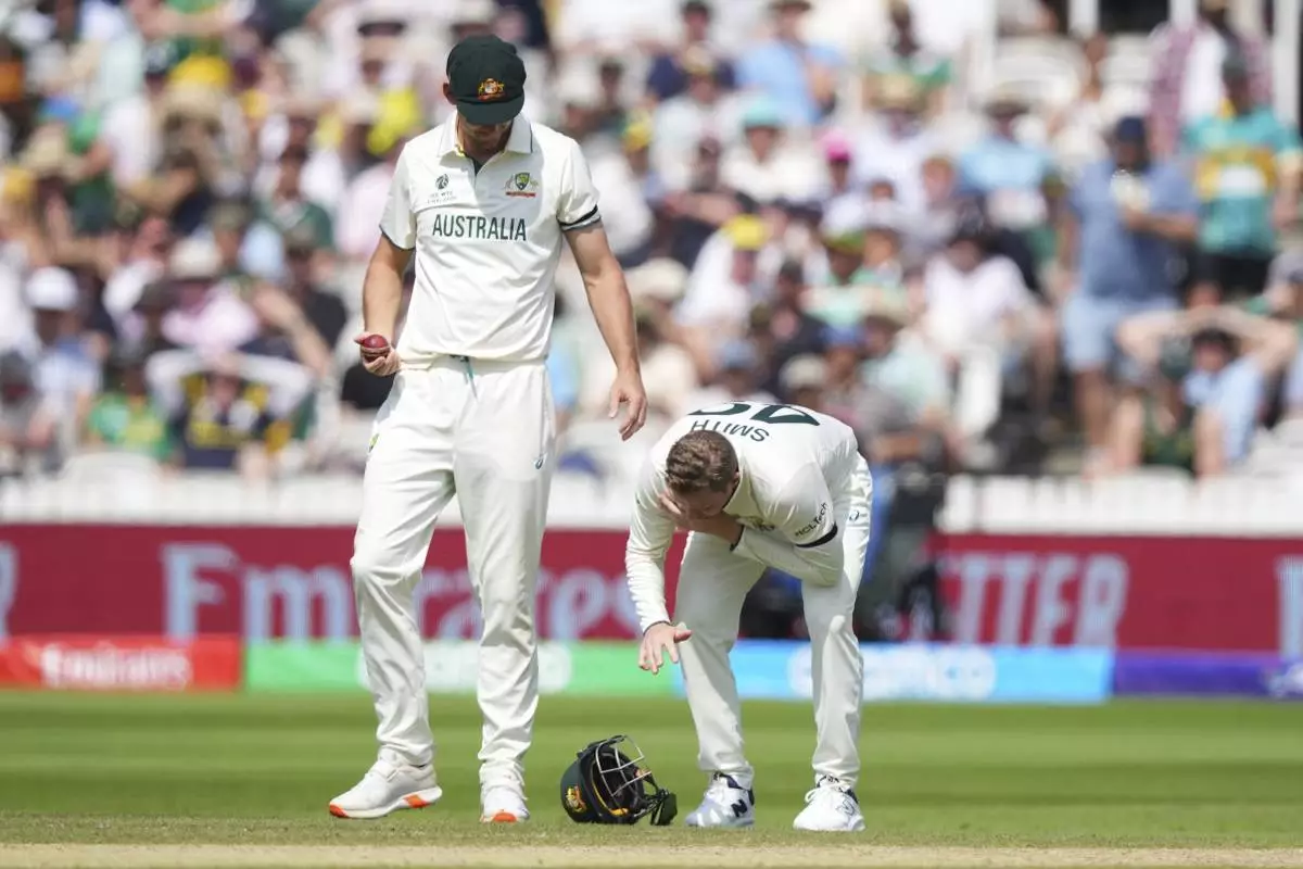 Australia's Steve Smith, right, reacts in pain after getting hurt while fielding on day three of the World Test Championship final between South Africa and Australia at Lord's cricket ground in London, Friday, June 13, 2025. (AP Photo/Kirsty Wigglesworth)