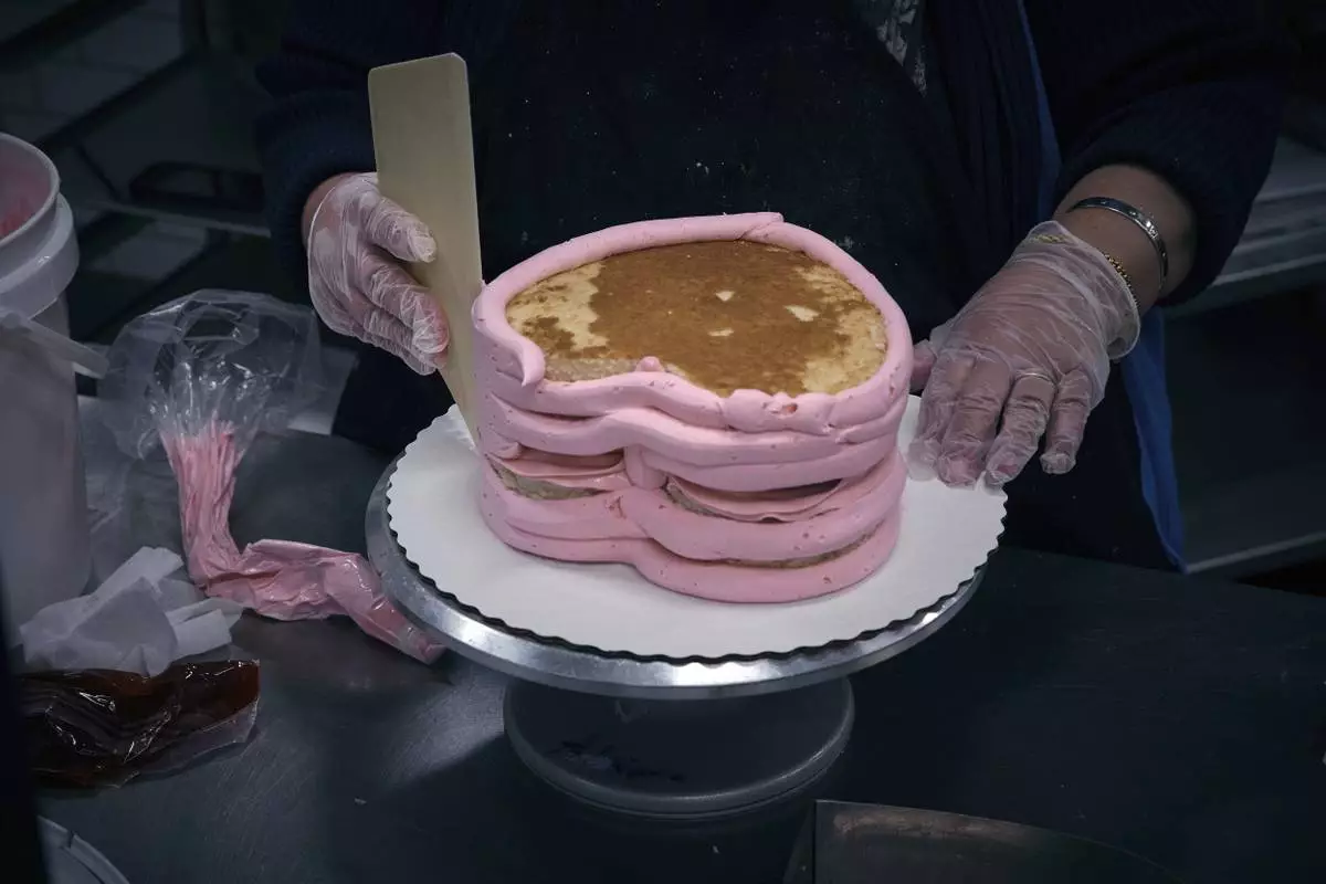 An employee makes a cake inside Walmart Supercenter on Wednesday, May 28, 2025, in North Bergen, N.J. (AP Photo/Andres Kudacki)