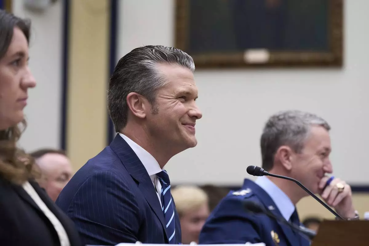 Secretary of Defense Pete Hegseth, flanked by Bryn MacDonnell, left, acting chief financial officer at the Department of Defense, and Gen. Dan Caine, chairman of the Joint Chiefs of Staff, fields questions on the Pentagon budget from the House Armed Services Committee, at the Capitol in Washington, Thursday, June 12, 2025. (AP Photo/J. Scott Applewhite)