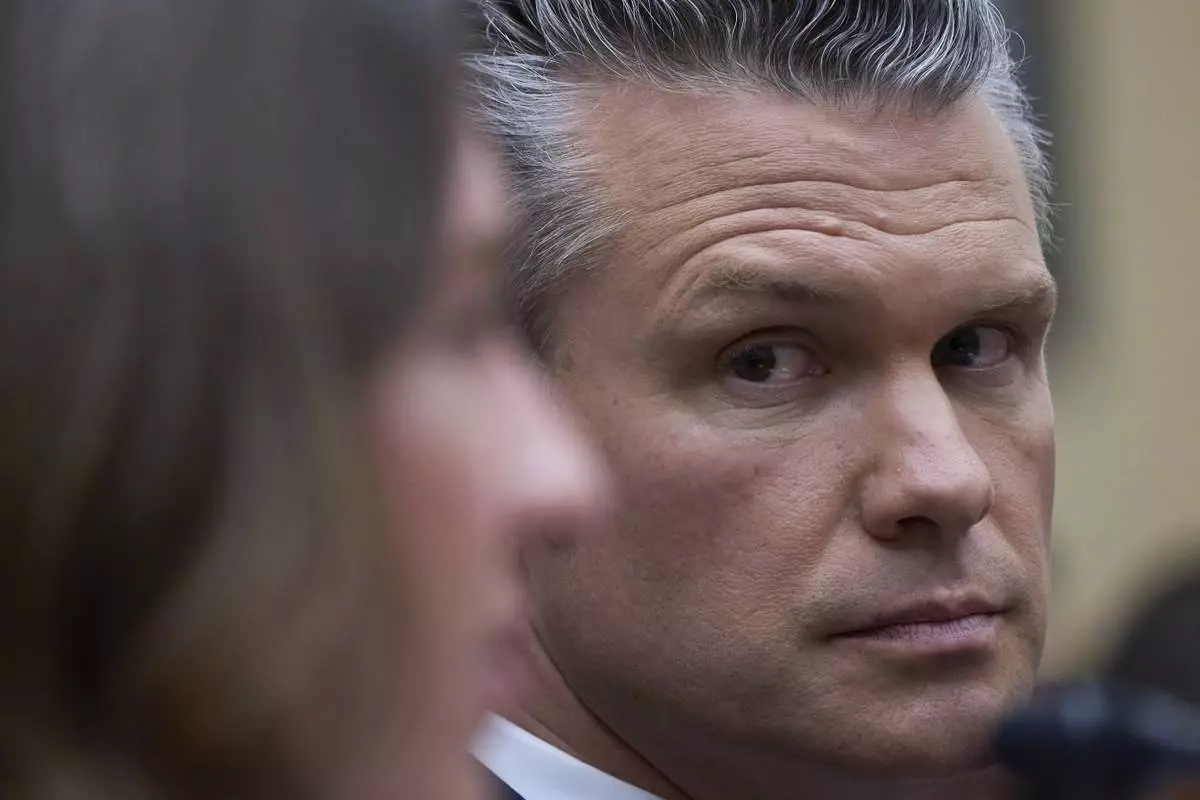 Secretary of Defense Pete Hegseth looks at Bryn MacDonnell, left, acting chief financial officer at the Department of Defense, as he fields questions on the Pentagon budget from the House Armed Services Committee, at the Capitol in Washington, Thursday, June 12, 2025. (AP Photo/J. Scott Applewhite)