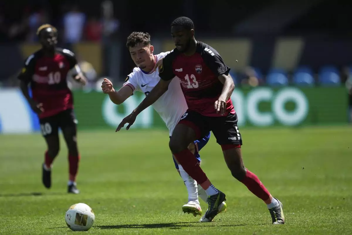 Trinidad and Tobago midfielder Tyrese Spicer (13) runs toward the ball against United States midfielder Sebastian Berhalter, front left, during the first half of a CONCACAF Gold Cup soccer match in San Jose, Calif., Sunday, June 15, 2025. (AP Photo/Jeff Chiu)