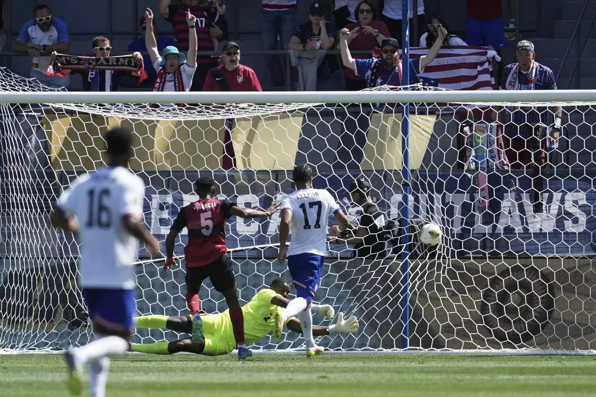 United States forward Malik Tillman (17) scores Trinidad and Tobago defender Justin Garcia (5) and goalkeeper Marvin Phillip, bottom, during the first half of a CONCACAF Gold Cup soccer match in San Jose, Calif., Sunday, June 15, 2025. (AP Photo/Jeff Chiu)